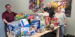 Scranton CCC staff stand beside table to donated items.