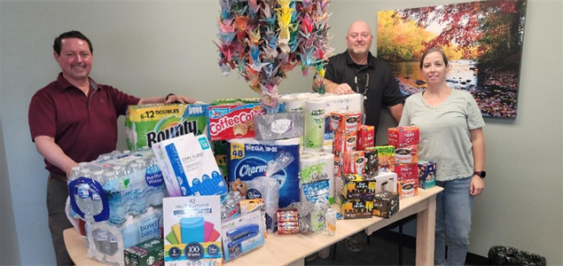 Scranton CCC staff stand beside table to donated items.