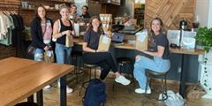 TLC reentrants and residents of Williamsport hold their self-care bags in a coffee shop.