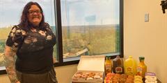 A woman stands next to a table of breakfast foods