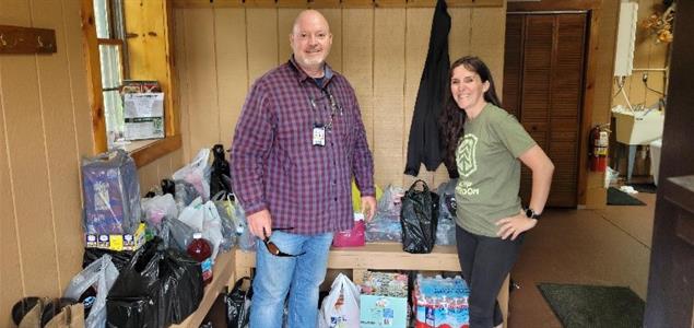 Two people standing with donated items