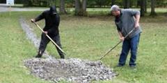 Two people raking stones