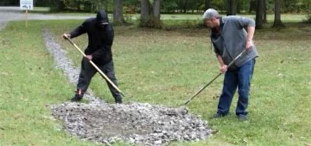 Two people raking stones
