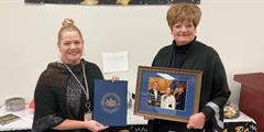 Department of Corrections Secretary Dr. Laurel Harry holds a certificate as Executive Deputy Secretary Tammy Ferguson holds a signed photo.