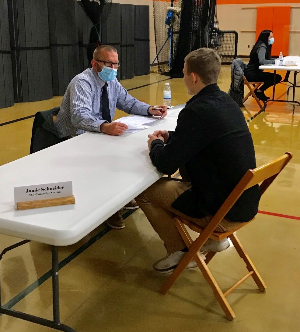 A DOC employee interviews a student