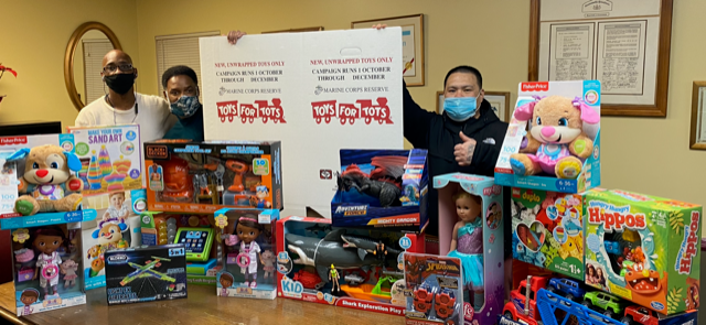 Reentrants stand with their Toys for Tots donations
