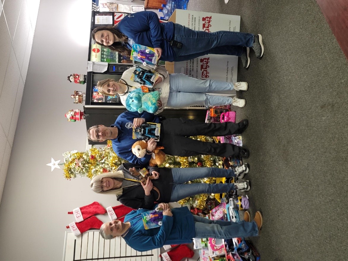 Five people hold donated toys.