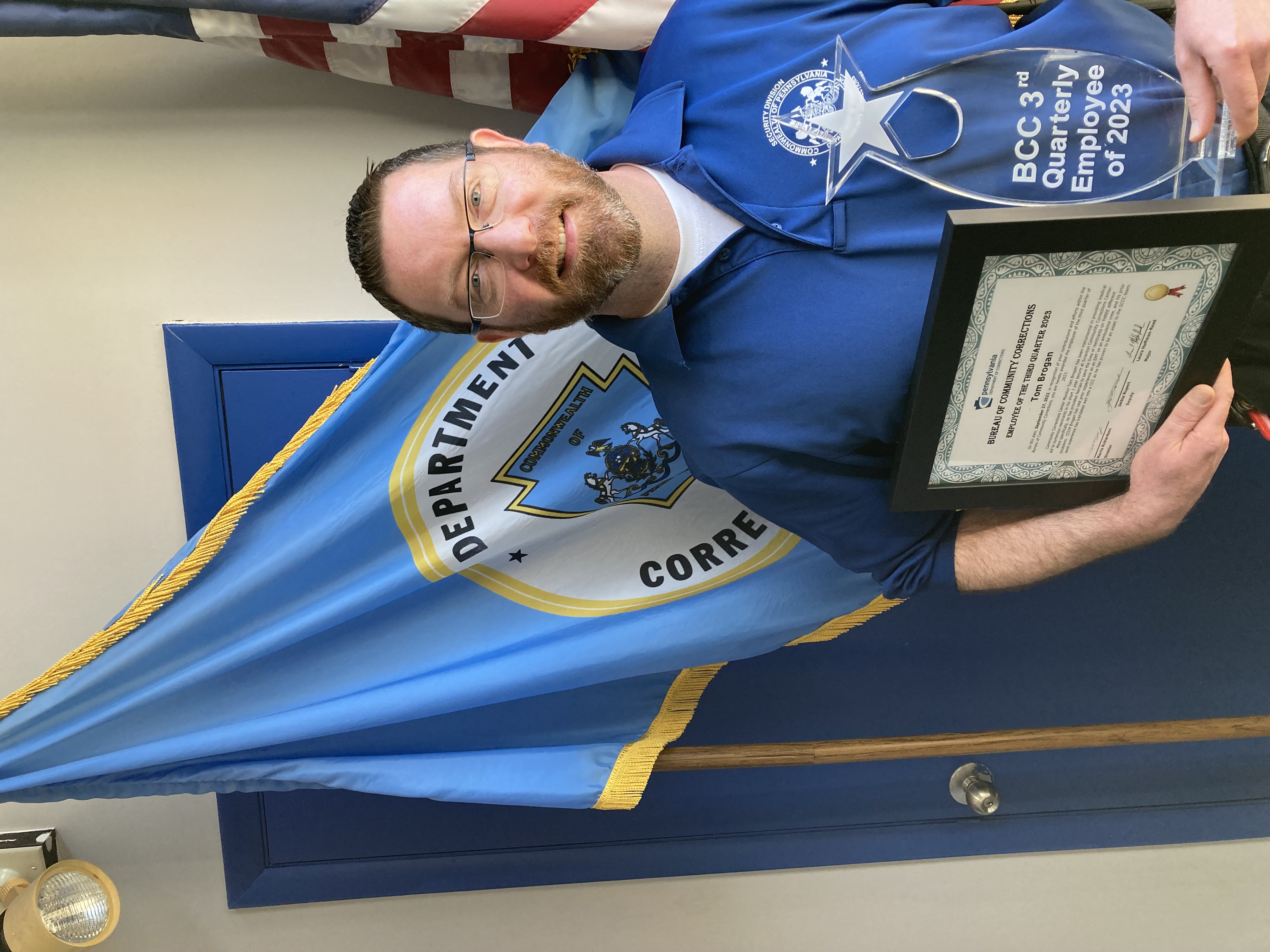 ​Scranton CCC Monitor Tom Brogan holds his certificate and trophy after being named Employee of the Quarter