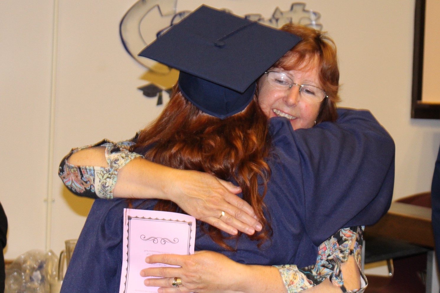 A family member hugs her inmate after graduation