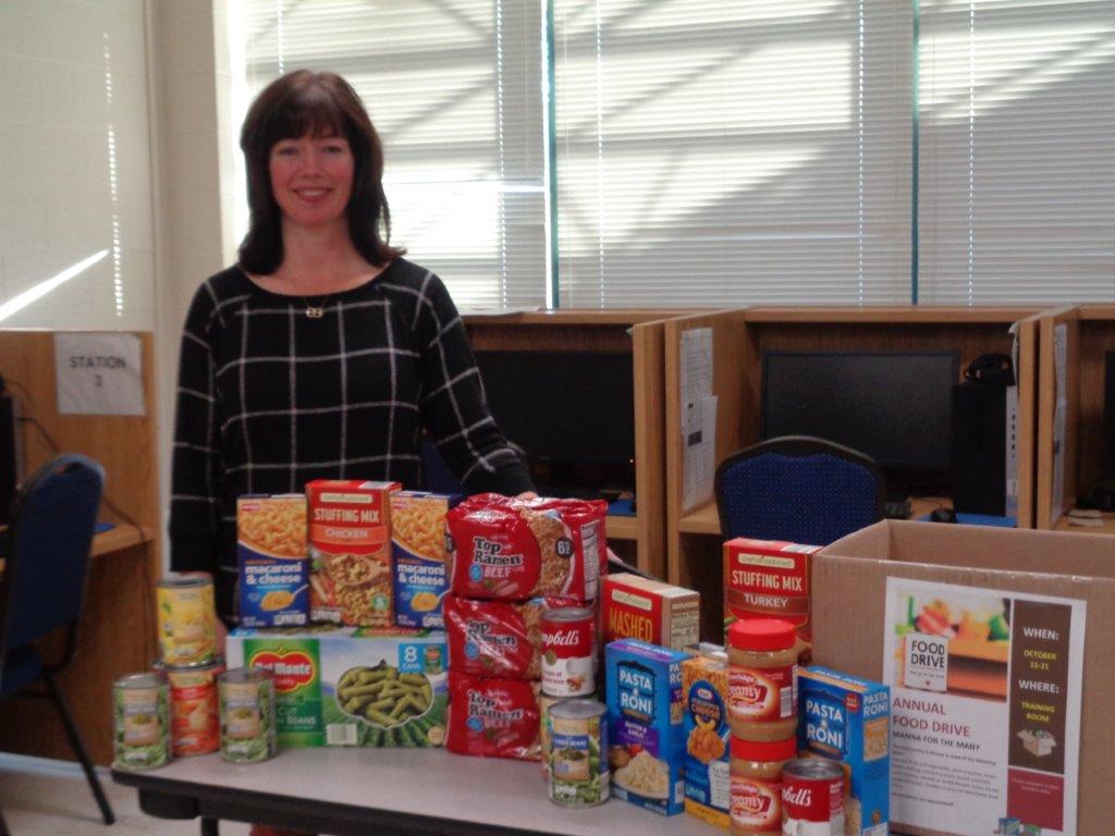 SCI Coal Township Mail Inspector Jodi Britton stands behind a table of donated food