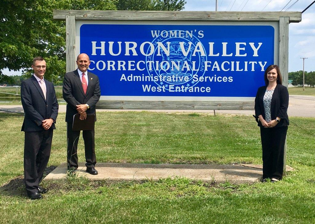 DOC auditors pose by a sign from a prison in Wisconsin