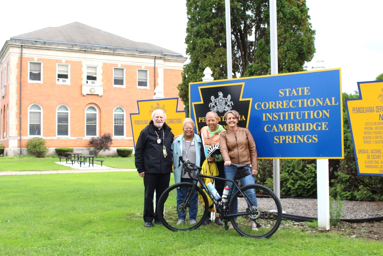 Three SCI Cambridge Springs employees with DOC Religious Services Administrator Ulli Klemm and his bike