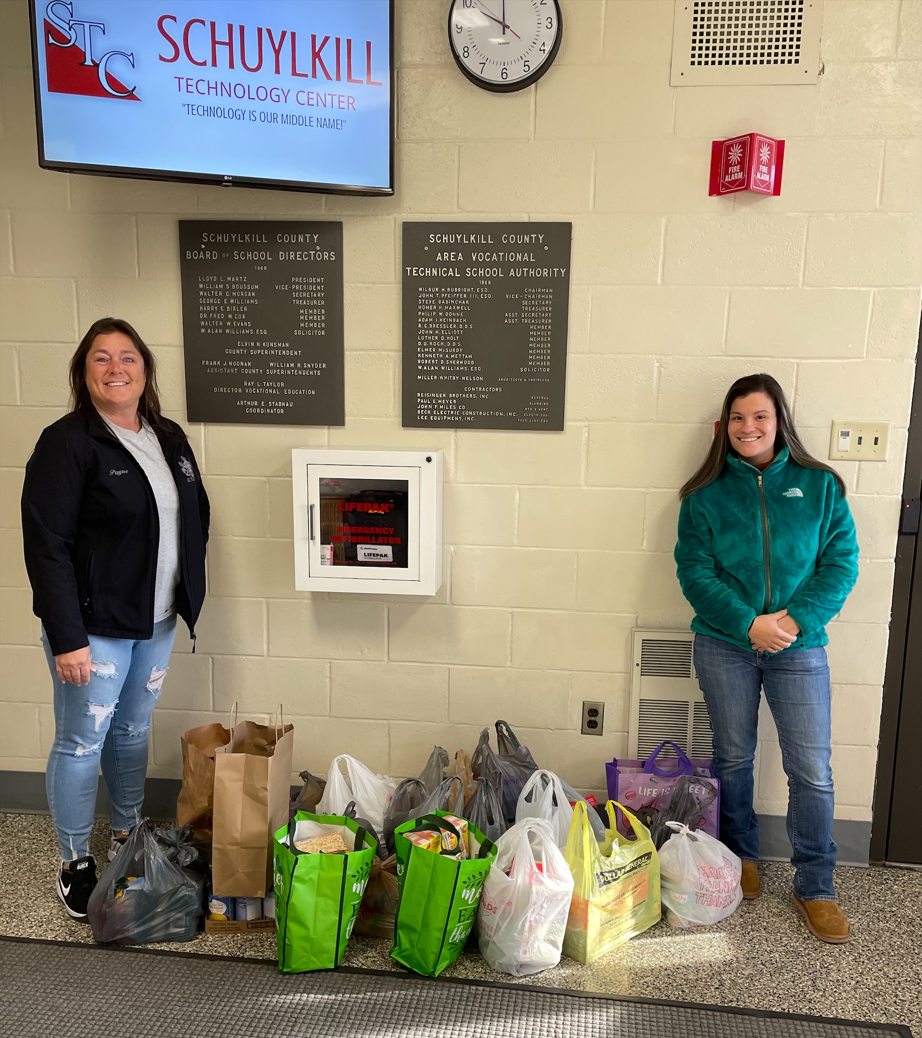Two SCI Frackville employees stand with donated food