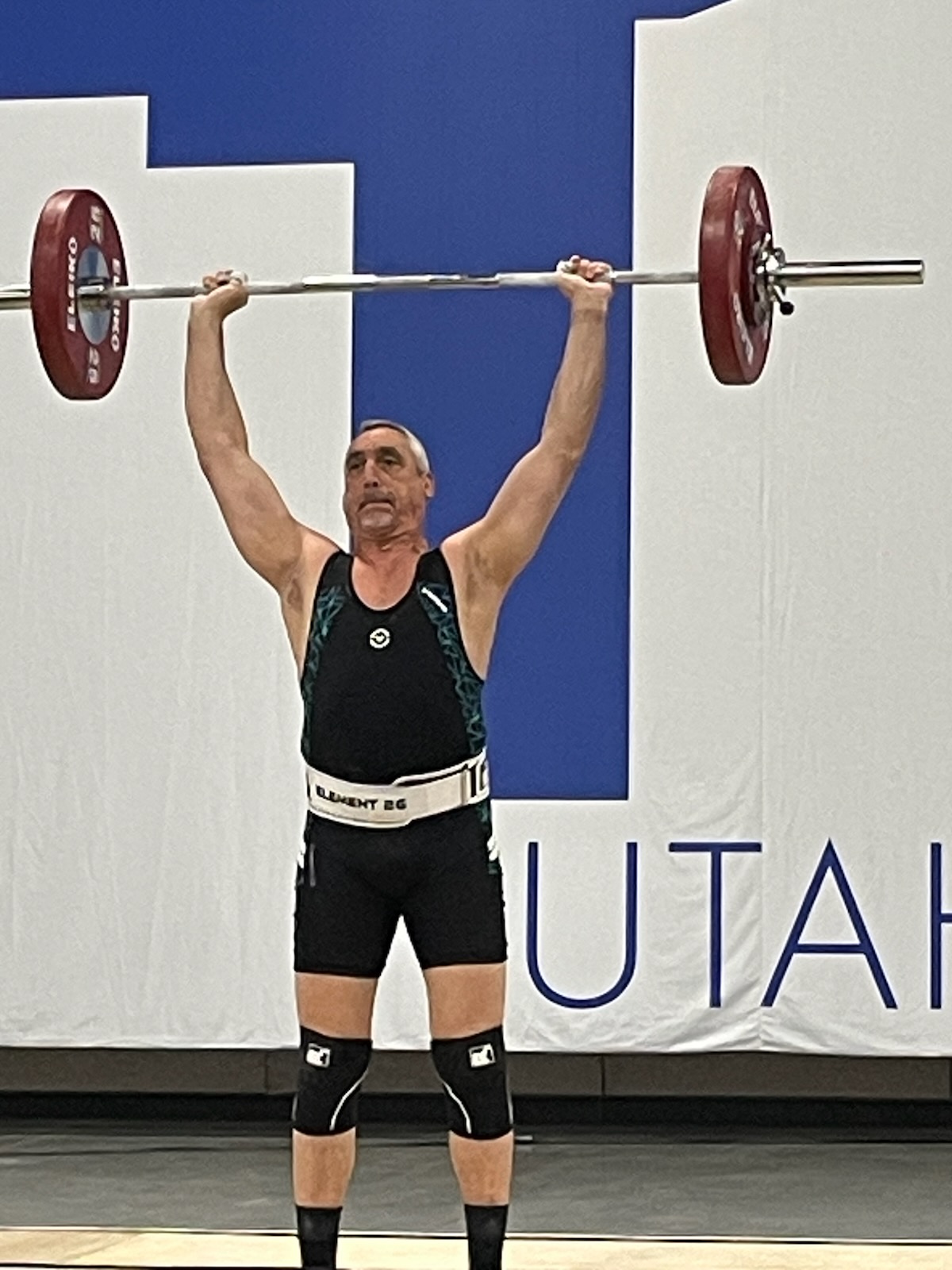 A man lifts a barbell over his head
