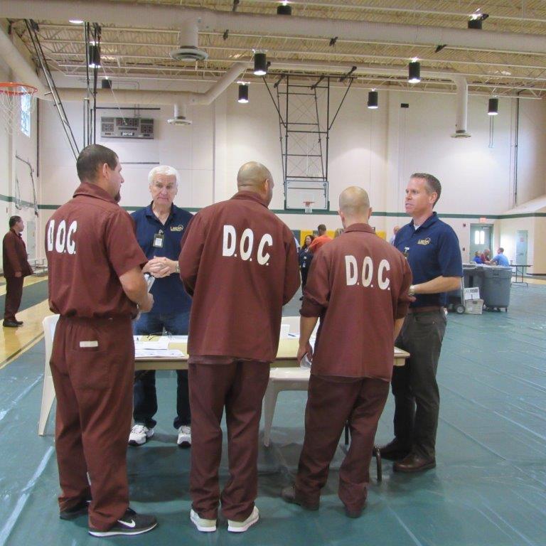 Inmates speak with employers at a reentry job fair