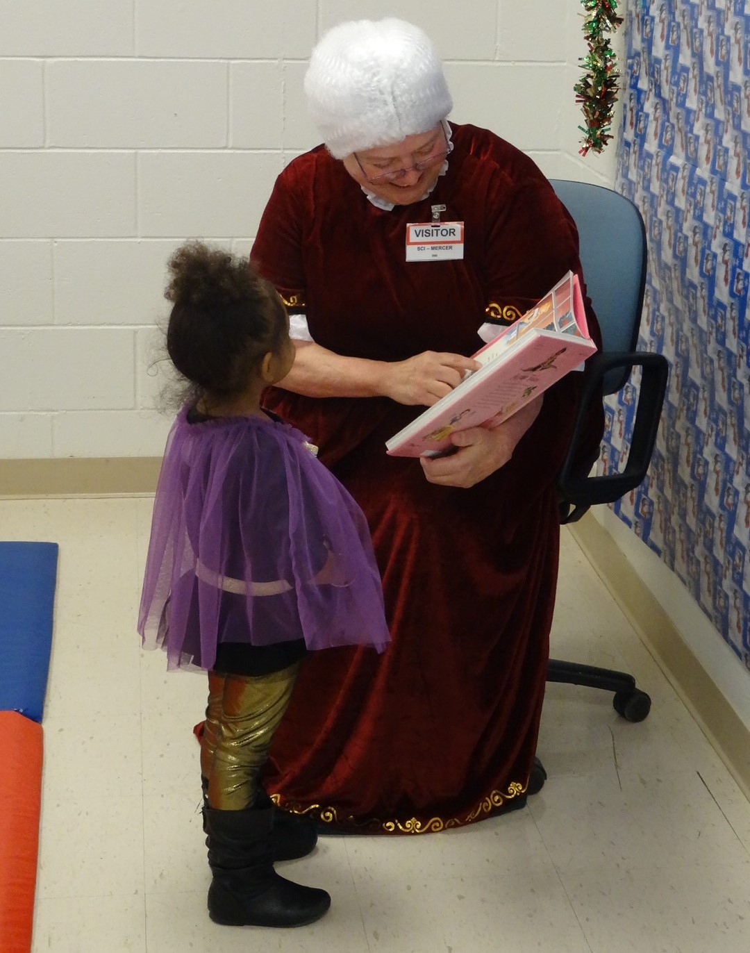 Mrs. Claus reads to a kid