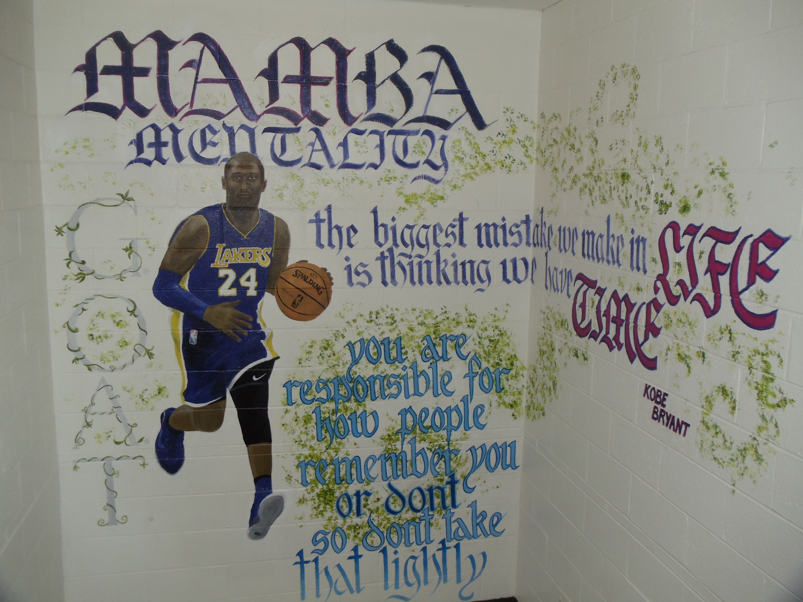 A mural of Kobe Bryant with a quote by him