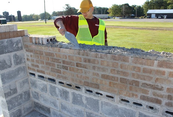 An inmate builds a wall