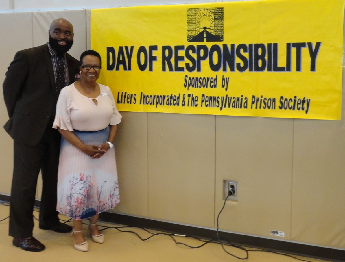 Volunteers stand by the Day of Responsibility banner
