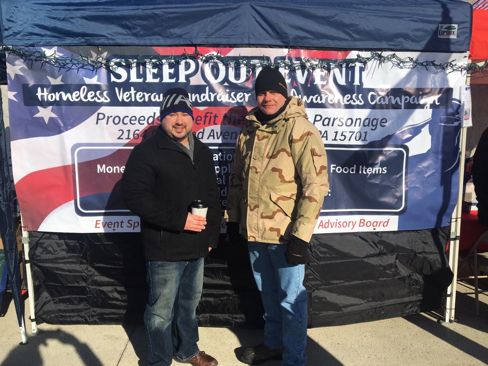 Two employees stand at a Sleepout event
