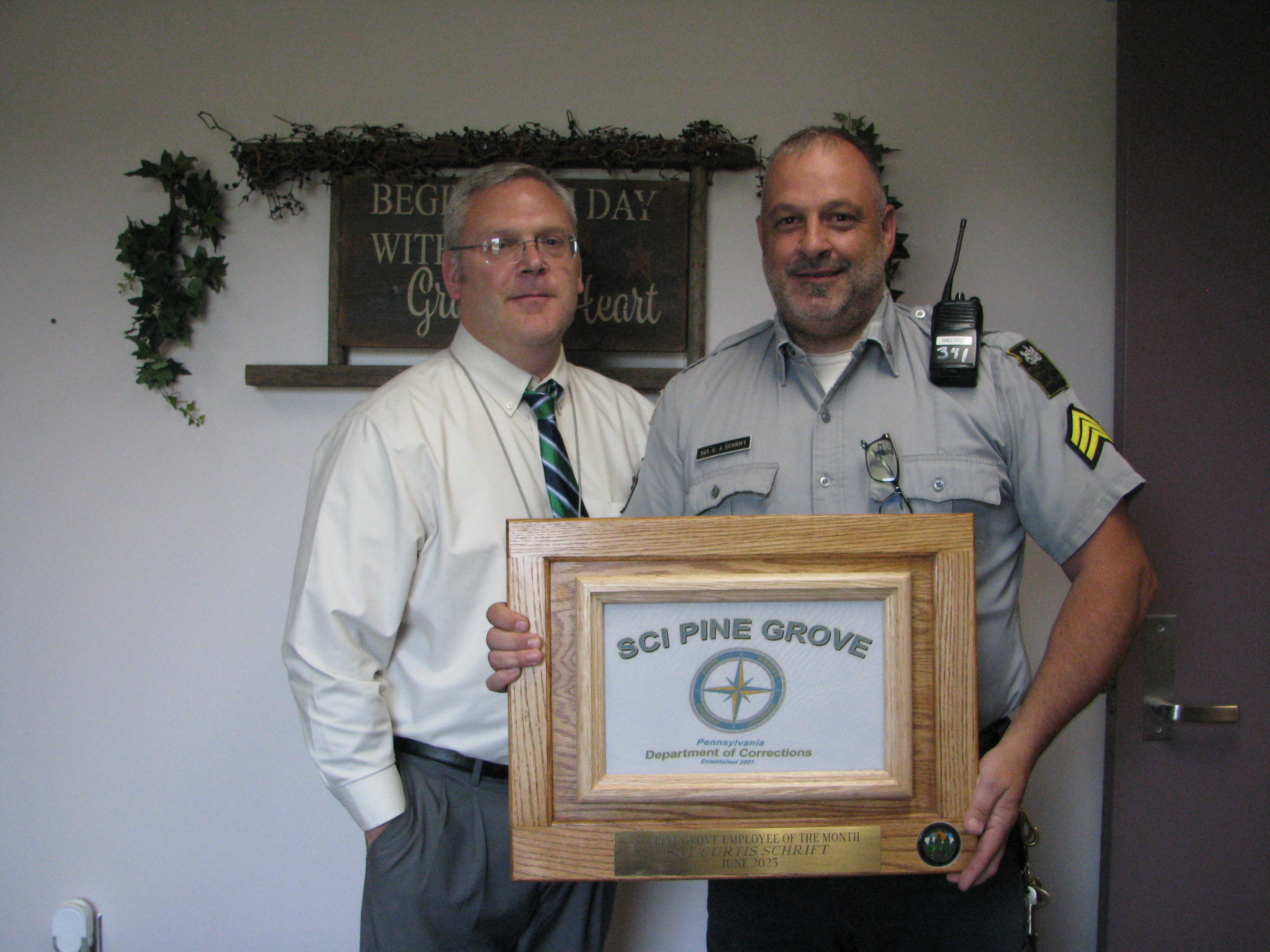 Sgt. Curtis Schrift holds his Employee of the Month certificate with Superintendent Mark Brothers.