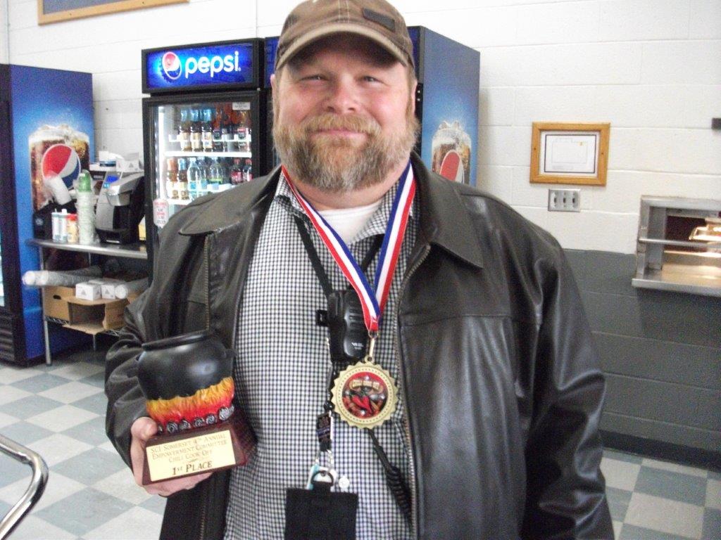An SCI Somerset employee holds his chili cook-off trophy