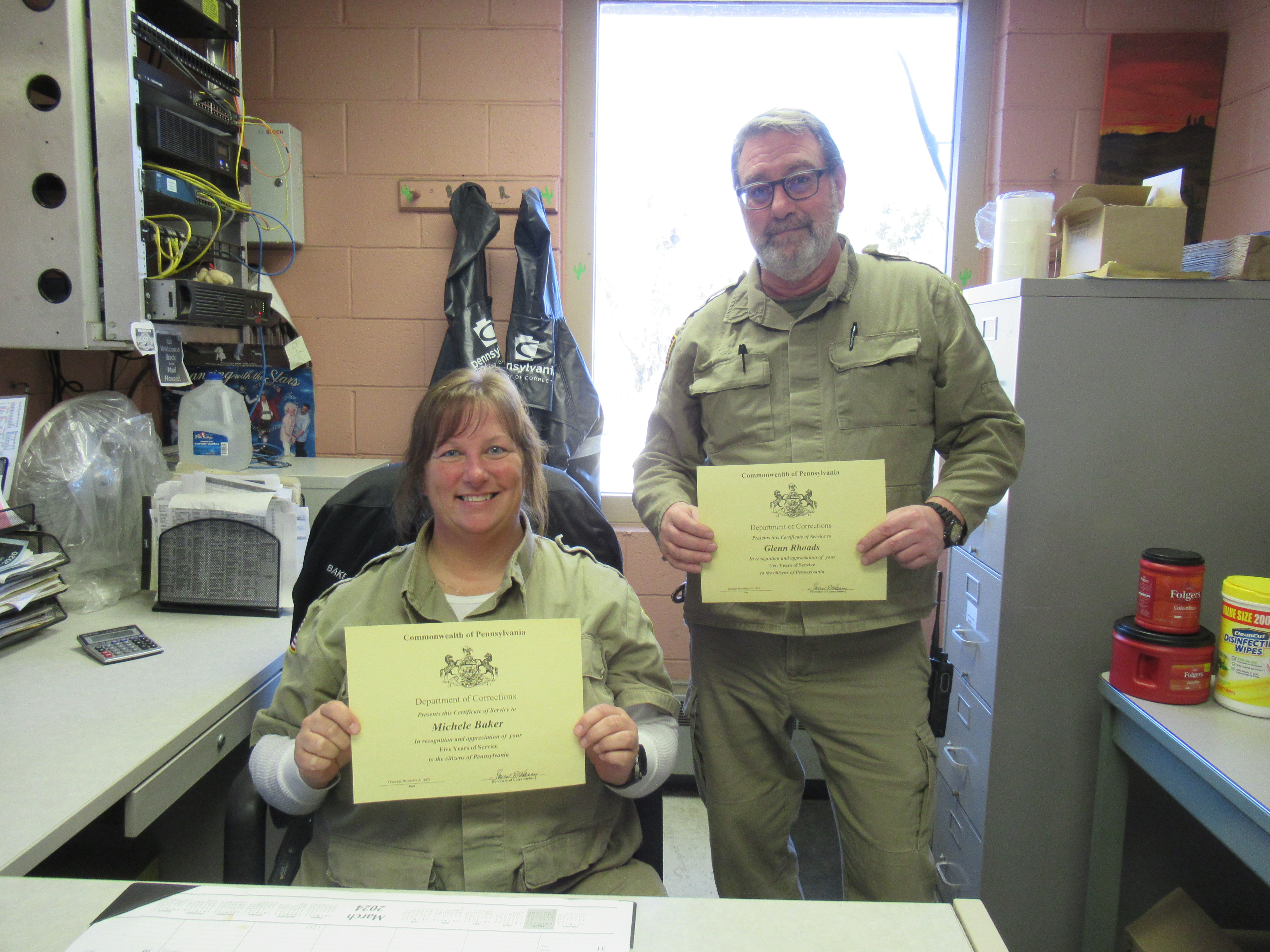 Stock Clerks Michele Baker and Glenn Rhoads holding certificates.