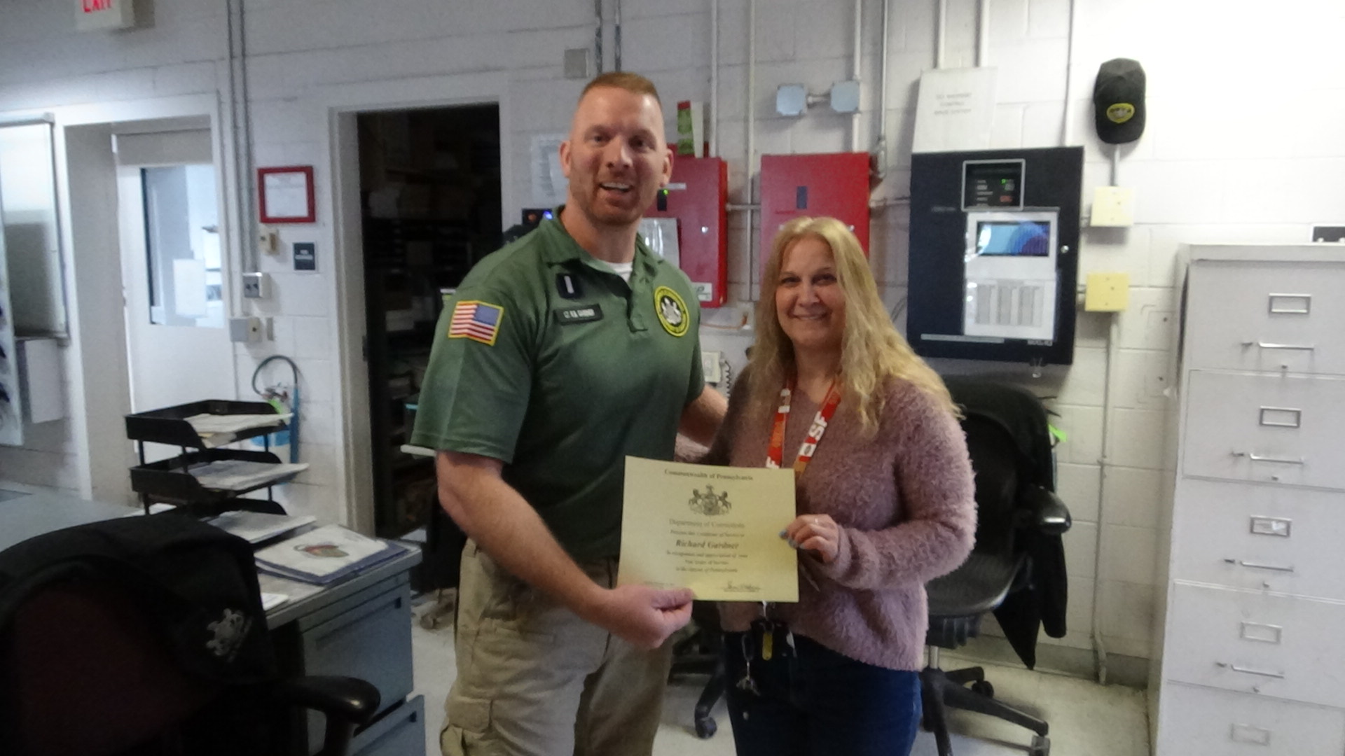 Lt. R. Gardner and CSA Christine Altemier holding a certificate.