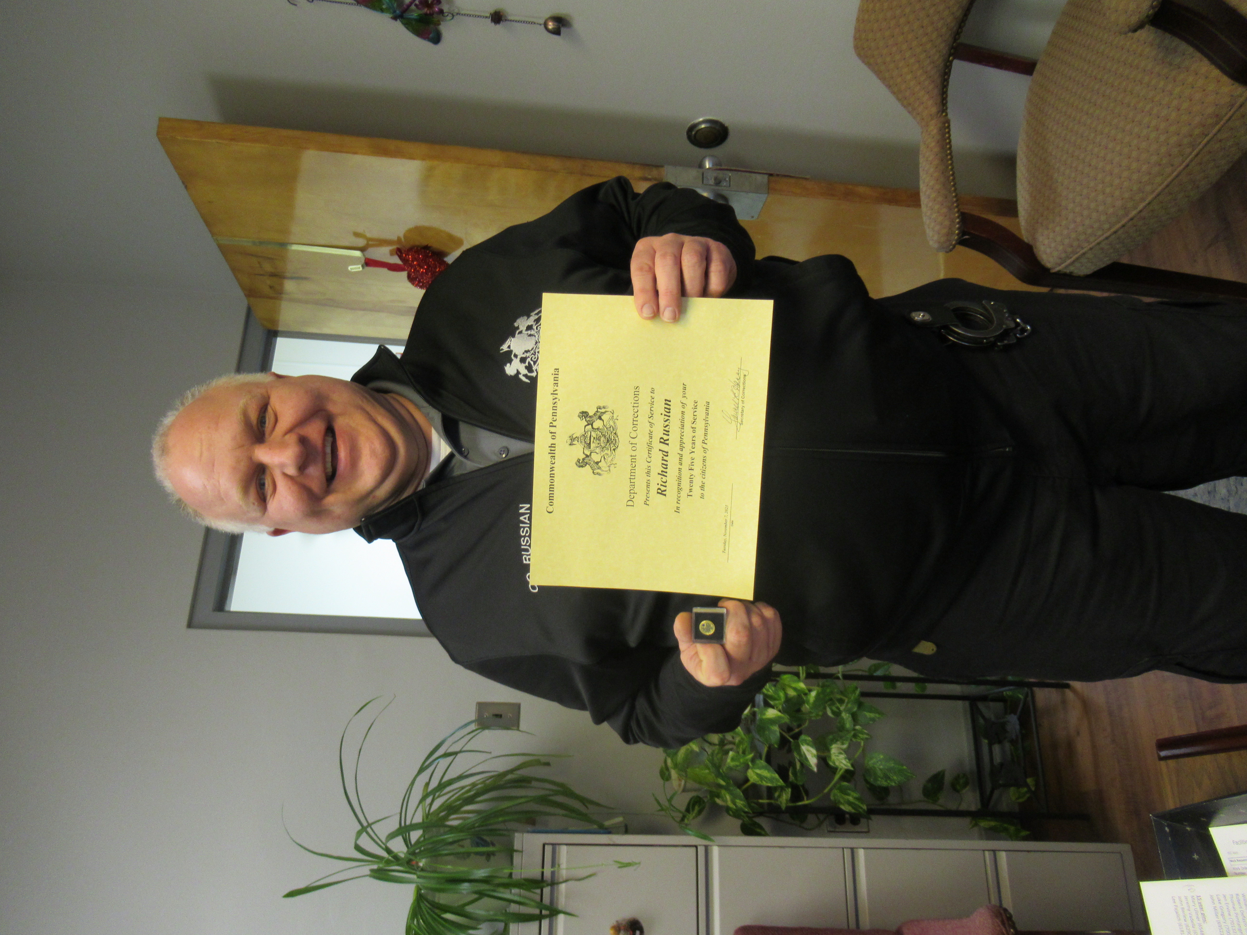 CO Richard Russian holds a certificate.