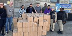 A group of Philadelphia parole staff around boxes of food