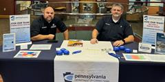 Two members of the DOC Recruitment and Retention Division sit at a table at St. Francis University.