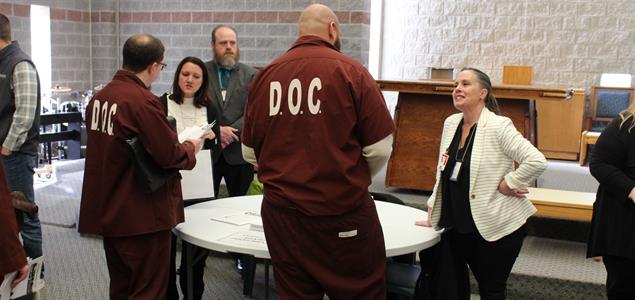 Two inmates talk to DOC staff