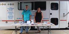 Two people stand outside the PA DMVA Mobile Outreach Van
