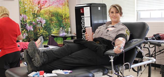 A corrections officer lays back while donating blood