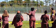 Incarcerated individuals at SCI Cambridge Springs throw bean bags into hula hoops as part of a Fall Festival.