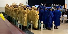Graduates from SCI Chester in yellow and blue caps and gowns at the ceremony.