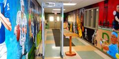 A hallway painted with murals featuring famous athletes.