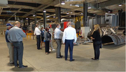A group of people visit the vehicle restoration plant
