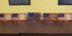Five wooden U.S. flags on a table