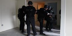 A group of DOC special teams members prepare to go through a doorway as part of a drill