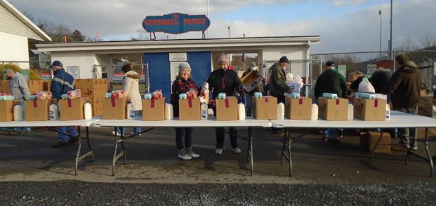 A group of people stand with boxes of food