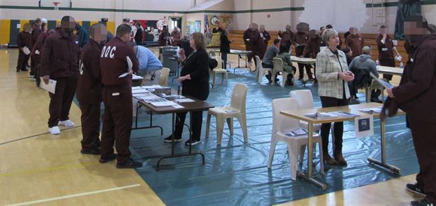 Inmates meet with participants at a reentry fair
