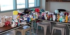 Two tables full of donated hygiene items.