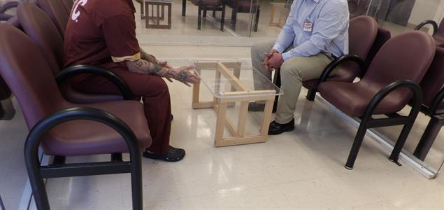 An incarcerated veteran sits across from a visitor at SCI Mercer