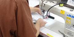 A man sews at a sewing machine