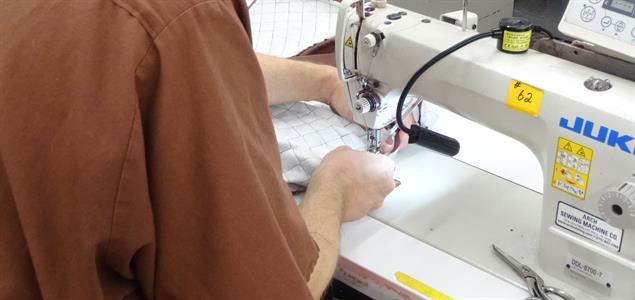 A man sews at a sewing machine