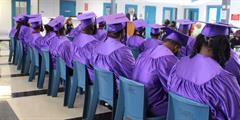 A group of graduates wearing purple caps and gowns
