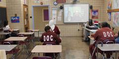 Inmates watch a virtual presentation