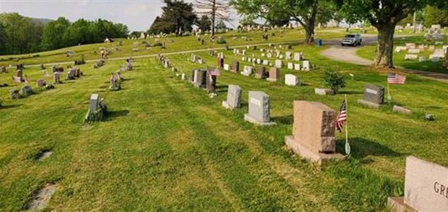 A cemetery with American flags by some headstones