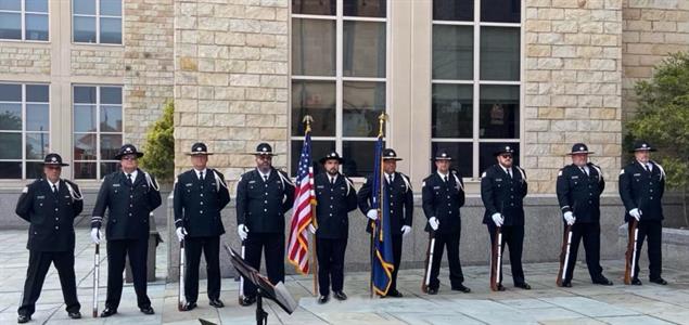 SCI Smithfield's Honor Guard stands holding flags for the memorial service.